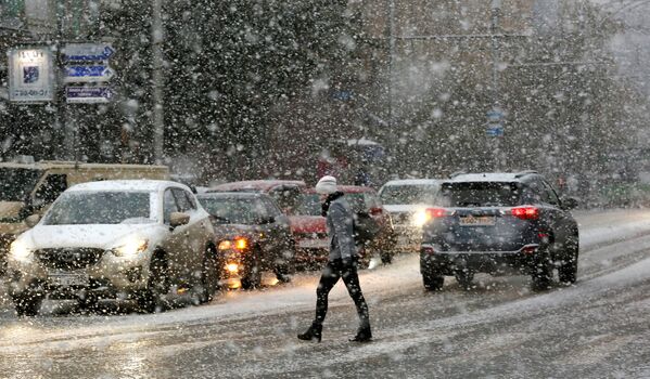 زنی در حال عبور از خیابانی در کراسنویارسک  هنگام ریزش برف - اسپوتنیک ایران  