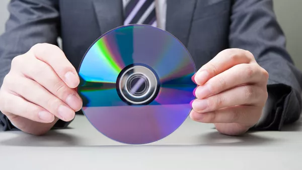 Человек в деловом костюме держит в руках CD - اسپوتنیک ایران  
