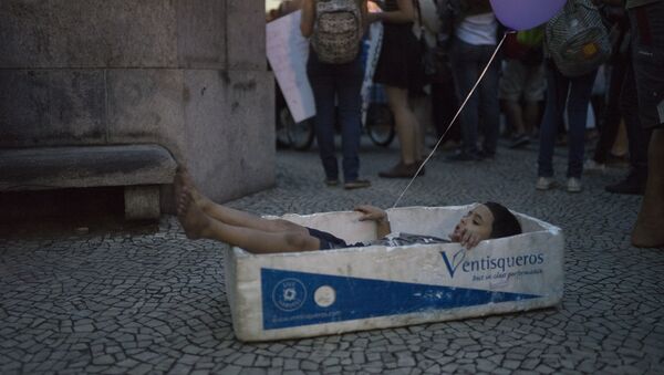 Мальчик в коробке для перевозки рыбы во время демонстрации против гендерного насилия в Рио-де-Жанейро, Бразилия - اسپوتنیک ایران  