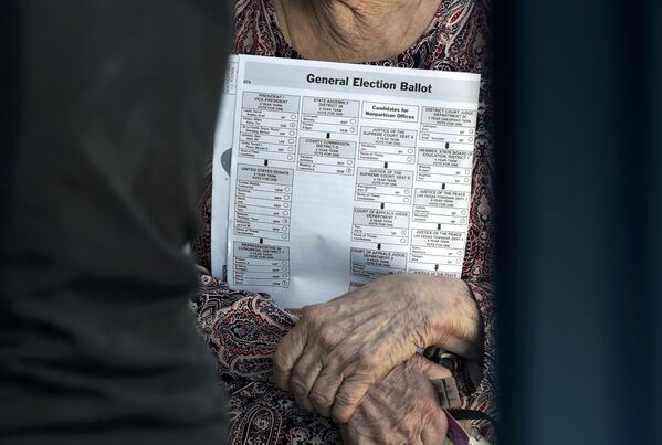 زنی با بولتن انتخاباتی در زمان رأی گیری در انتخابات ریاست جمهوری آمریکا در لاس وگاس - اسپوتنیک ایران  