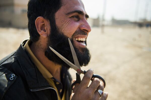 مرد عراقی با رسیدن به  نیروهای عراقی  در حومه موصل ریشش را می زند - اسپوتنیک ایران  