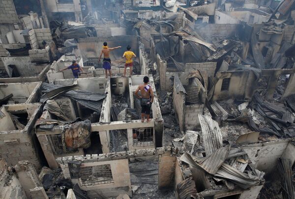 ساکنان محل بر پشت بام خانه  سوخته در « ماندالیونگ»  فیلیپین - اسپوتنیک ایران  