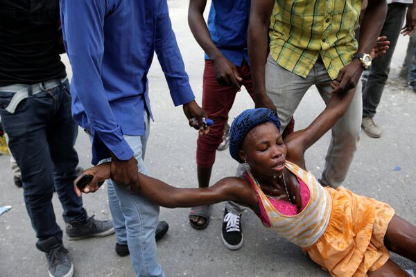 زنی آسیب دیده بر اثر گاز اشک آور  در اعتراضات هائیتی - اسپوتنیک ایران  