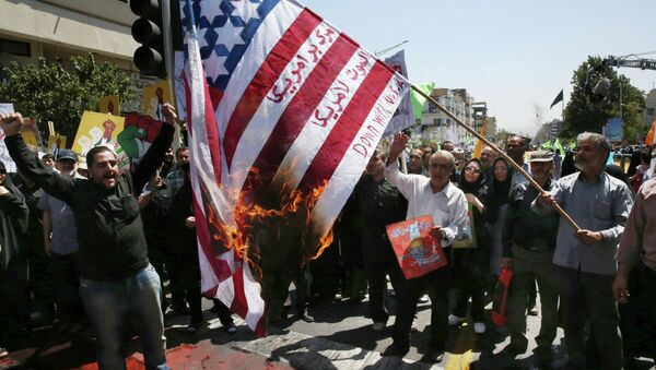 Iranian demonstrators burn a representation of the U.S. flag reading down with America, in Arabic and Persian, during an annual pro-Palestinian rally marking Al-Quds (Jerusalem) Day at the Enqelab-e-Eslami (Islamic Revolution) St. in Tehran, Iran, Friday, July 10, 2015 - اسپوتنیک ایران  