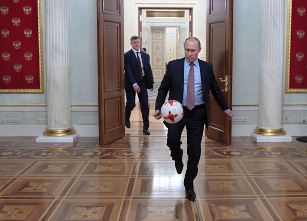 ولادیمیر پوتین، رئیس‌جمهور روسیه  با توپ پس از دیدار با جیانی اینفانتینو، رئیس فیفا در کرملین.  - اسپوتنیک ایران  
