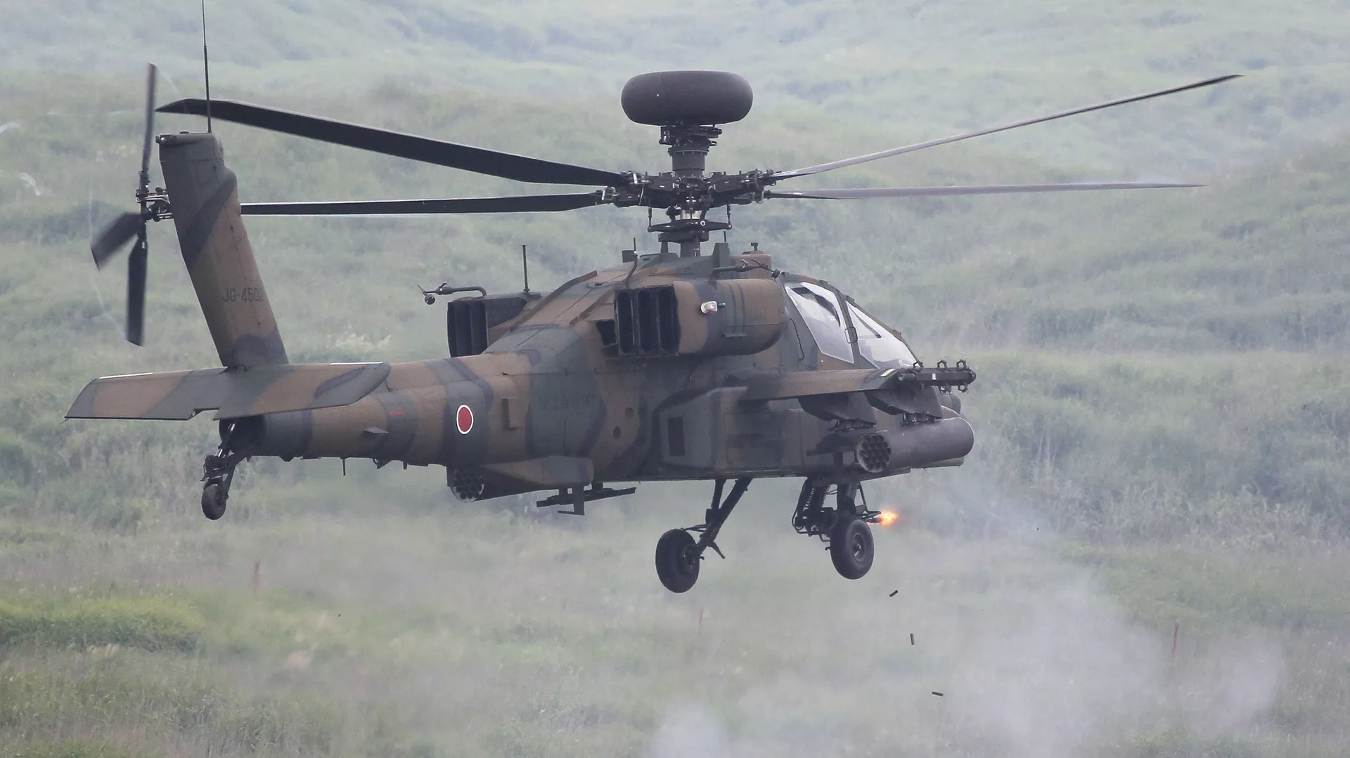 An AH-64D Apache attack helicopter fires during a fire military exercise at the Higashi-Fuji training range near Mt. Fuji in Gotemba, Shizuoka prefecture on August 23, 2011