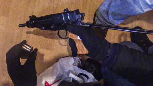 Сотрудник правоохранительных органов демонстрирует огнестрельное оружие и магазин с патронами к нему, изъятое сотрудниками ФСБ РФ у задержанной в Москве диверсионно-террористической группы - اسپوتنیک ایران  