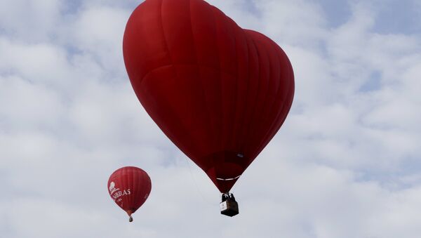 A heart-shaped hot air balloon (R) flies in the sky during the Love Cup 2016 event, ahead of Valentine's Day, in Jekabpils, Latvia, February 13, 2016 - اسپوتنیک ایران  
