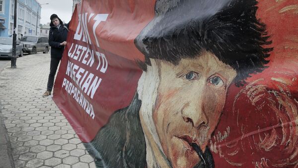 Киевский активист с плакатом «Не слушайте российской пропаганды» - اسپوتنیک ایران  