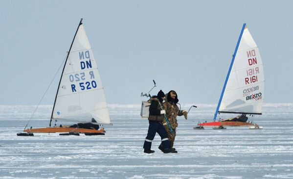 ماهیگیران و شرکت کنندگان مسابقه قایقرانی روی یخ بر سطح یخ زده خلیج آمور در ولادی واستوک - اسپوتنیک ایران  