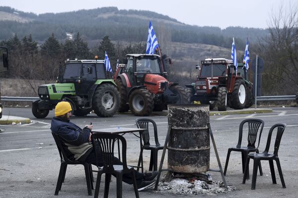 مزرعه دار یونان در کنار تراکتورهایی  که  در مرز یونان – مقدونیه جاده را بسته اند - اسپوتنیک ایران  
