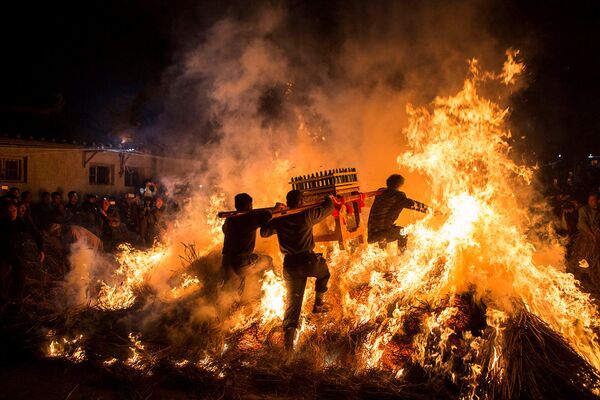 مردی در کنار هیمه آتش در جشن سال نو چینی در « سزیان» چین - اسپوتنیک ایران  