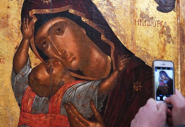 بازدیدکننده در حال عکس گرفتن از شمایل « مریم مقدس و نوزادش» در نمایشگاه « شاهکارهای بیزانس» در گالری تریتیاکوف مسکو - اسپوتنیک ایران  