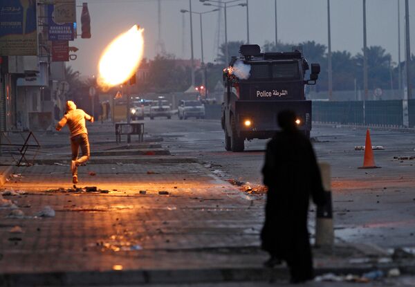 تظاهرکننده ای در حال پرتاب بطری آتش زا در تظاهرات بحرین - اسپوتنیک ایران  