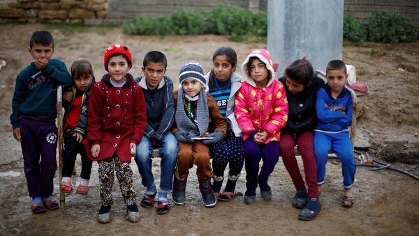 Езидский мальчик Айман, выкупленный у ДАИШ, среди детей после возращения в родной иракский город Дахук - اسپوتنیک ایران  