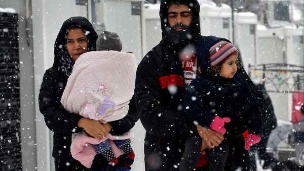 Stranded Syrian refugees carry their children through a snow storm at a refugee camp north of Athens, Greece January 10, 2017. - اسپوتنیک ایران  