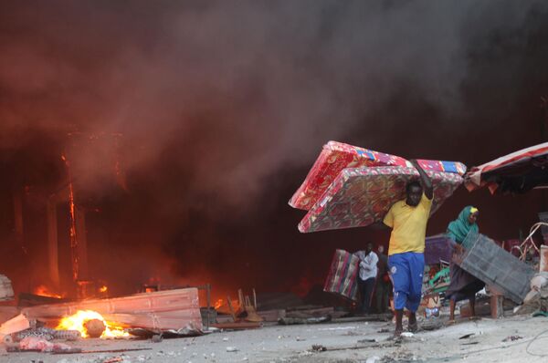 فروشندگان در حال نجات کالاهای خود در زمان آتش سوزی در بازار  موگادیشو سومالی - اسپوتنیک ایران  