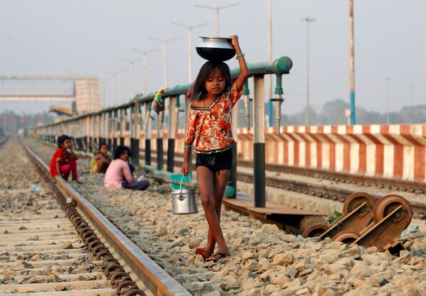 دختری در حال  حمل کوزه آب روی سر در امتداد  خط راه آهن در هند - اسپوتنیک ایران  