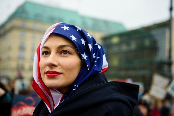 زنی که در زمان اعتراضات در برلین از پرچم آمریکا به عنوان حجاب استفاده کرده است - اسپوتنیک ایران  