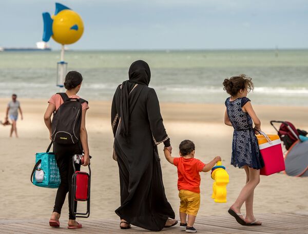زن مسلمان با حجابی همراه فرزندان خود در پلاژی در شمال فرانسه - اسپوتنیک ایران  