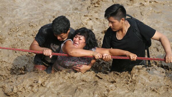 Женщина пересекает реку во время наводнения в Перу - اسپوتنیک ایران  