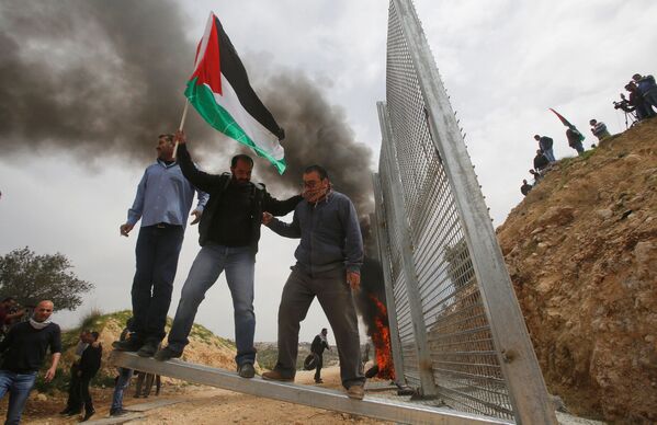 تظاهرکنندگان فلسطینی  در حال شکستن حصارهای اسرائیلی در زمان تظاهرات در شهر  بیت الجلا - اسپوتنیک ایران  