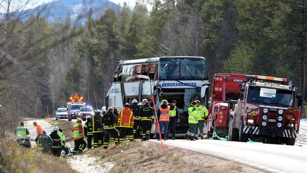 Rescue workers are seen at the site where a bus carrying school children and adults rolled over on a road close to the town of Sveg, in northern Sweden April 2, 2017 - اسپوتنیک ایران  