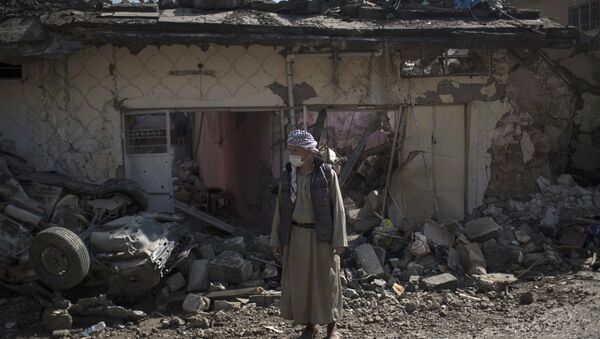 A man stands outside houses damaged during fights between Iraq security forces and Islamic State on the western side of Mosul, Iraq, Friday, March 24, 2017. - اسپوتنیک ایران  
