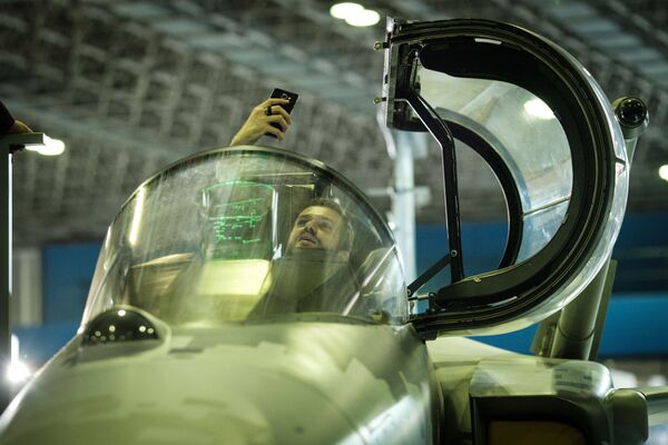 بازدیدکننده در حال گرفتن عکس در کابین جنگنده SAAB Gripen E در نمایشگاه سیستم های هوایی و دفاع « LAAD 2017» در برزیل - اسپوتنیک ایران  