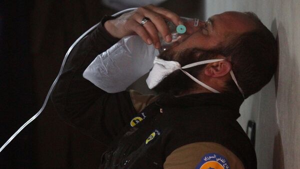 A civil defence member breathes through an oxygen mask, after what rescue workers described as a suspected gas attack in the town of Khan Sheikhoun in rebel-held Idlib, Syria April 4, 2017. - اسپوتنیک ایران  