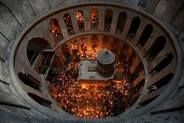 مومنان شمع به دست در زمان دریافت آتش مقدس  در  کلیسای مسیح در اورشلیم - اسپوتنیک ایران  