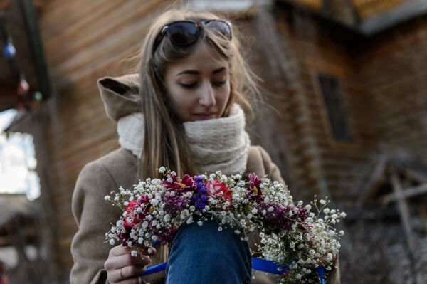 دختری در حال بافتن تاج سر از گل ها در اولین جشنواره عشاق در مسکو - اسپوتنیک ایران  