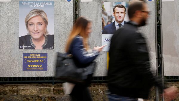 People walk past campaign posters of Marine Le Pen (L), French National Front (FN) political party leader, and Emmanuel Macron (R), head of the political movement En Marche! (Onwards!), two of the eleven candidates who run in the 2017 French presidential election in Paris, France, April 10, 2017 - اسپوتنیک ایران  