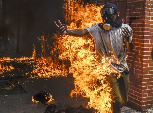 تظاهرکننده گرفتار آتش  بر اثر انفجار باک بنزین  موتورسیکلت  در زمان تظاهرات در ونزوئلا - اسپوتنیک ایران  