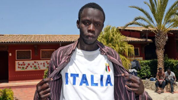 Мигрант позирует в футболке с надписью Italia после прибытия в иммиграционный центр Palazzolo Acreide - اسپوتنیک ایران  