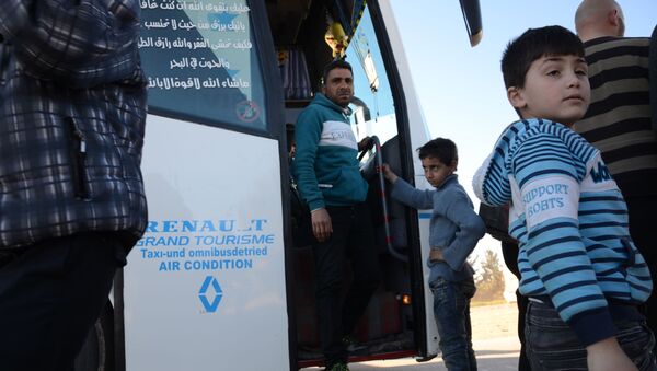 Мужчина с мальчиком в автобусе, вывозящем боевиков и их семей из пригорода Аль-Ваер на севере Хомса - اسپوتنیک ایران  