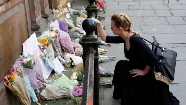 Девушка рядом с цветами в память о погибших во время теракта в Манчестере - اسپوتنیک ایران  