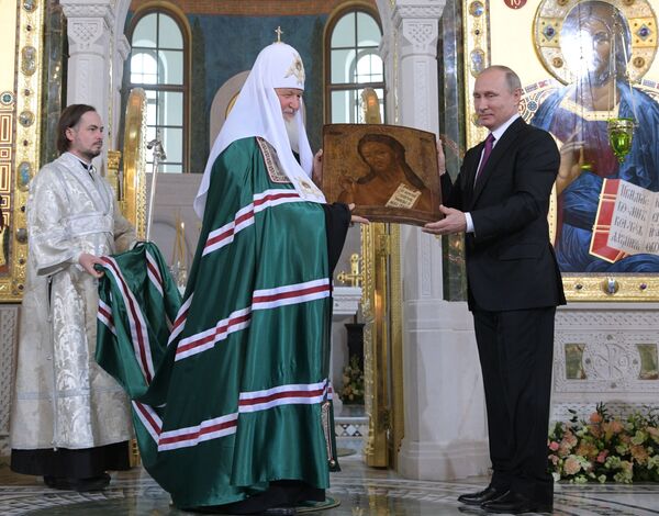 پاتریک کیریل اسقف اعظم مسکو به همراه ولادیمیر پوتین رئیس جمهور روسیه به هنگام بازدید از شمایل یحیی (یوحنا) در کلیسای سرتنسکی در مسکو - اسپوتنیک ایران  