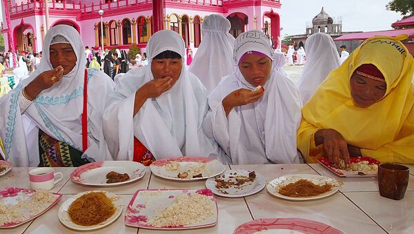Филиппинские мусульманки принимают пищу во время празднования Ураза-байрам - اسپوتنیک ایران  