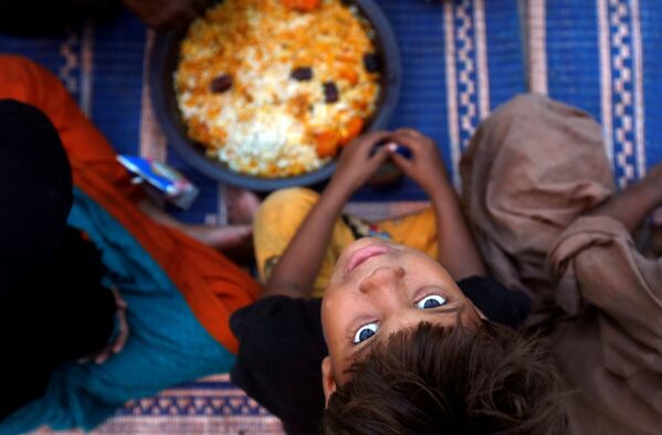 پسربچه ای در زمان تقسیم غذا در ماه رمضان در پاکستان - اسپوتنیک ایران  