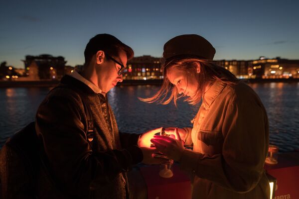 شرکت کنندگان راهپیمایی وطنپرستانه «خط خاطرات» در حال روشن کردن شمع به یاد کشته شدگان در جنگ کبیر میهنی در ساحل «کریمسکی» در امتداد رودخانه مسکو - اسپوتنیک ایران  