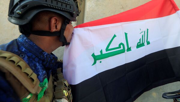 Сотрудник федеральной полиции Ирака целует иракский флаг в Западном Мосуле - اسپوتنیک ایران  