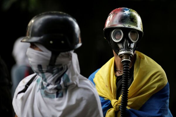 تظاهر کنندگان با ماسک ضد گاز در کاراکاس - ونزوئلا - اسپوتنیک ایران  