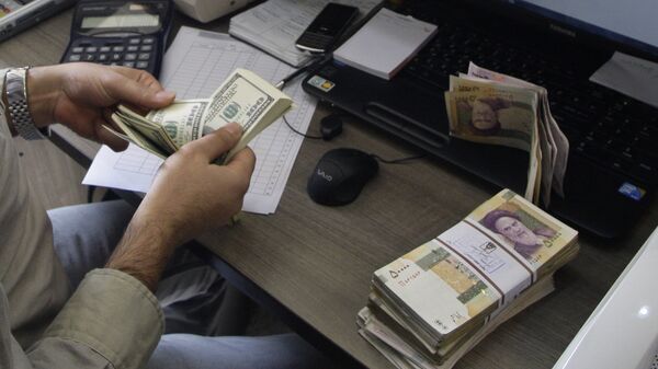 A currency exchange bureau worker counts US dollars, as Iranian bank notes are seen at right with portrait of late revolutionary founder Ayatollah Khomeini. - اسپوتنیک ایران  