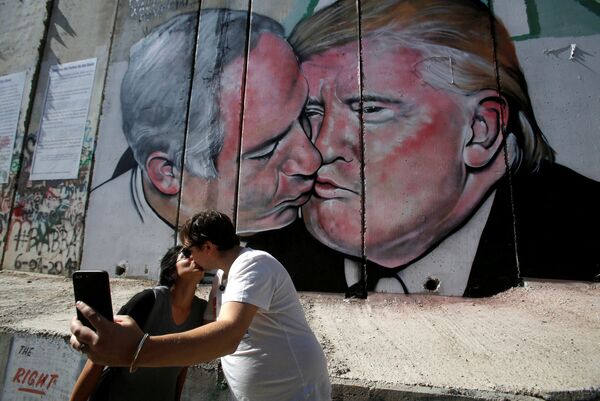 توریست ها با گرافیتی بوسه نتانیاهو و ترامپ روی دیوار ویفلیم فلسطین عکس می گیرند - اسپوتنیک ایران  