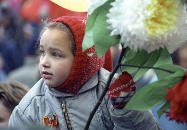 دختربچه ای با گلی در دست در راه پیمایی کارگران در میدان سرخ به مناسبت جشن انقلاب اکتبر - اسپوتنیک ایران  