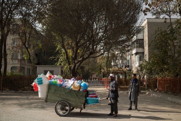 مردی در حال فروش ظرفهای پلاستیکی در کوچه ای واقع در کابل - اسپوتنیک ایران  