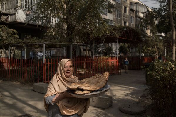 زنی با نان تازه در دستانش در یکی از کوچه های کابل - اسپوتنیک ایران  