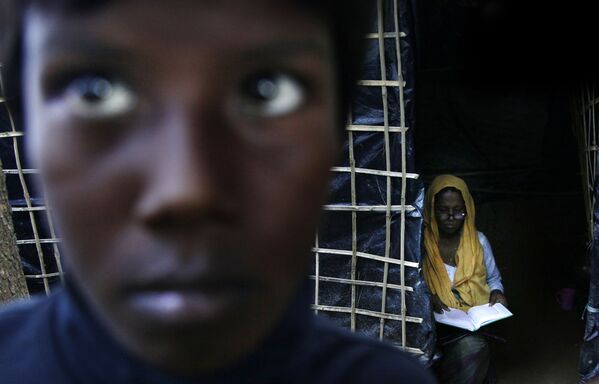 زن روهینگیایی در حال خواندن قرآن در اردوگاهی در بنگلادش - اسپوتنیک ایران  