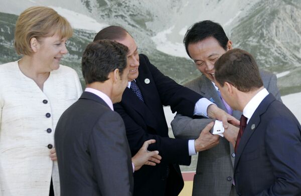 سیلویو برلوسکونی در حال نشان دادن سنجاق سردست تاگو آسو، نخست وزیر ژاپن  به رهبران دیگر ،2009، ایتالیا - اسپوتنیک ایران  